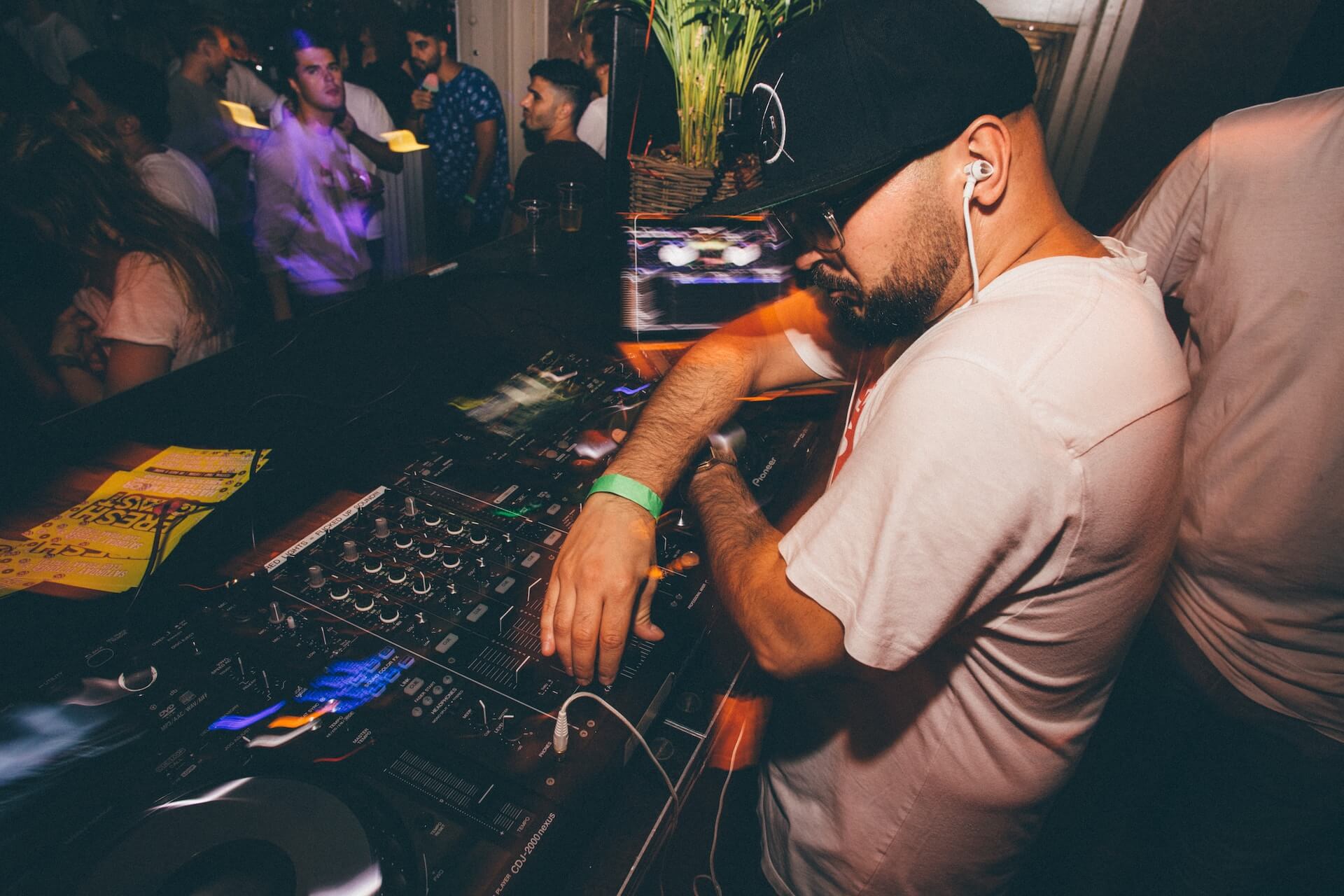 DJ operating a mixer during a live performance.